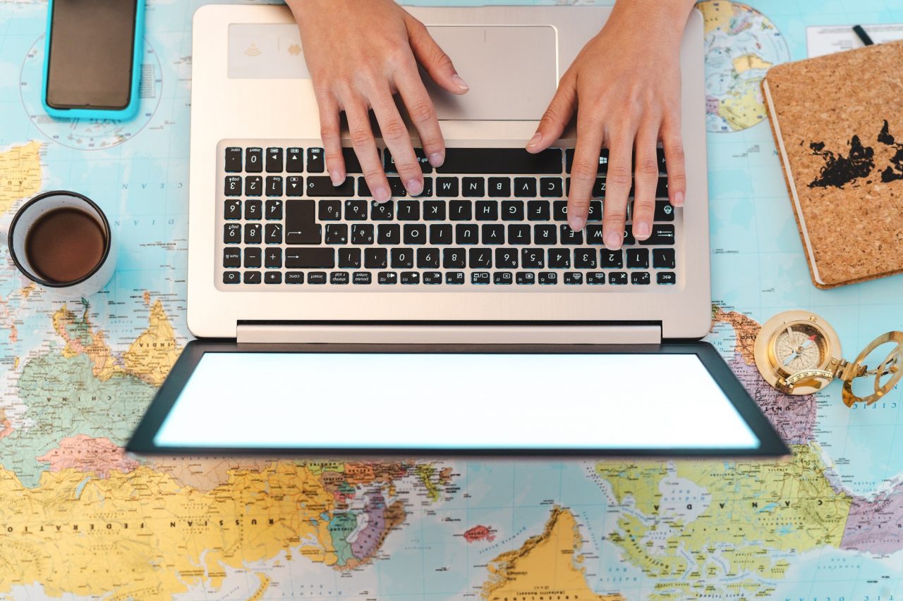 top-view-female-hands-using-laptop-on-world-map-booking-next-travel-destinations.jpg