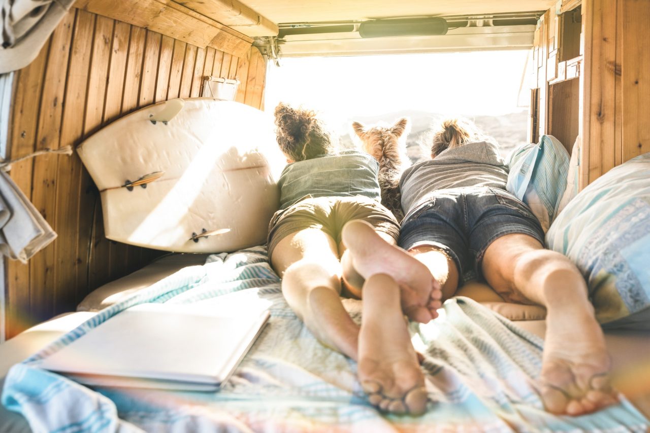 young-couple-with-dog-traveling-with-dog-on-vintage-minivan.jpg